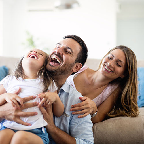 family laughing on couch