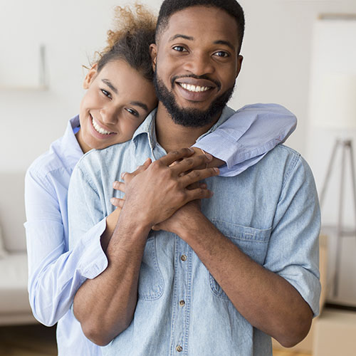young couple hugging in home
